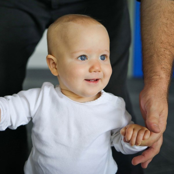 Dad holds up his daughter to dance during music classes for babies.