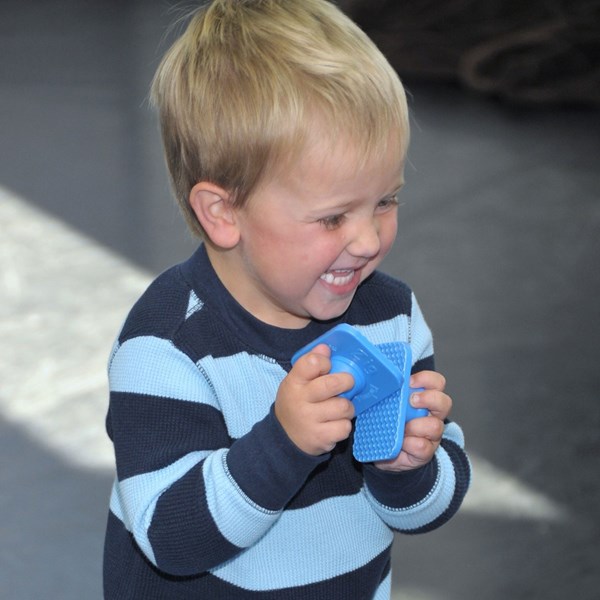 Early preschooler uses zig zag blocks during music classes for families.