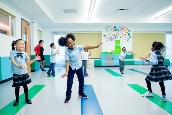 School children dancing during Kindermusik class. Music in schools post-COVID. 