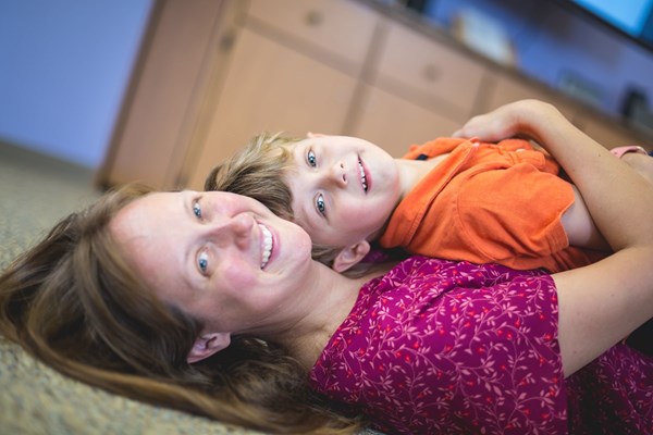 Mom and 3-year-old son resting on the floor during music classes for older toddlers.