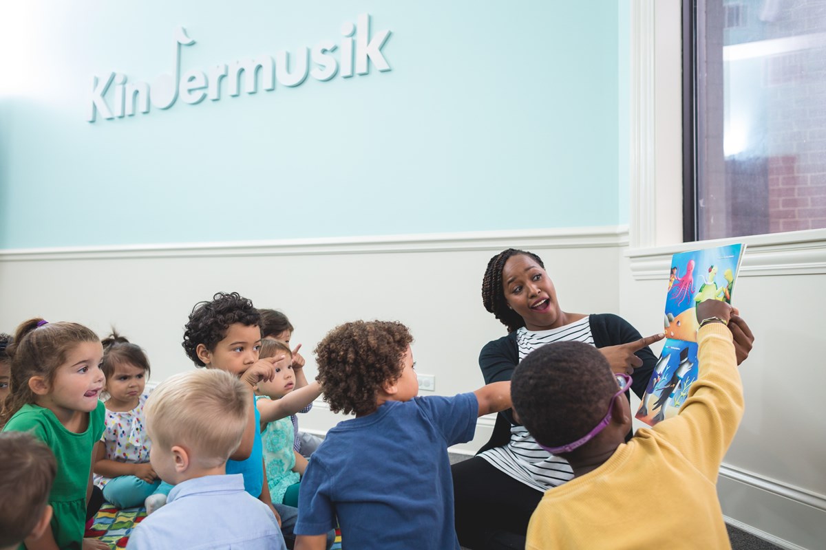 Children reading a story. Music and movement research on how Kindermusik boosts language and literacy skills.